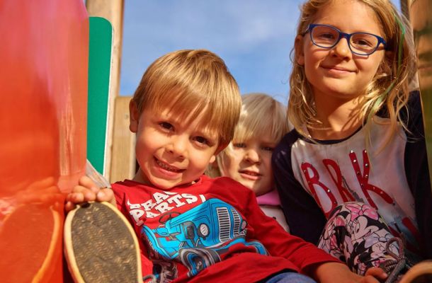 Kinder auf der Rutsche beim Spielplatz rund um das Hotel